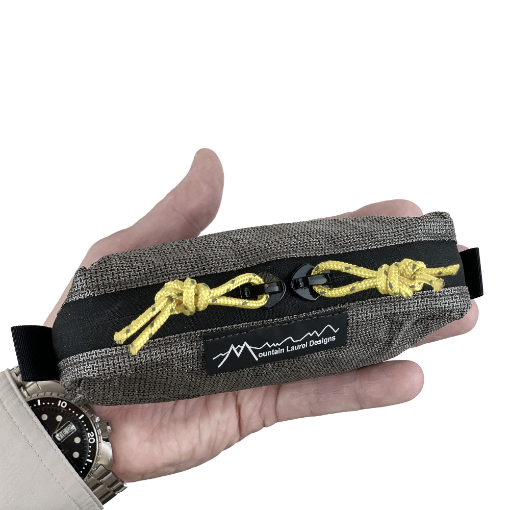 A small ECOPAK ULTRA packing cube in a man's hand.