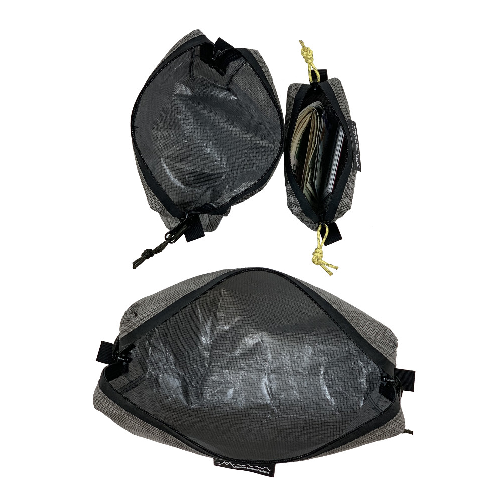 An open (unzipped) view of the ECOPAK ULTRA PACKING CUBES looking down. The medium and small are on the top; the large is on the bottom. The small one contains ID and a fat stack of folded bills.