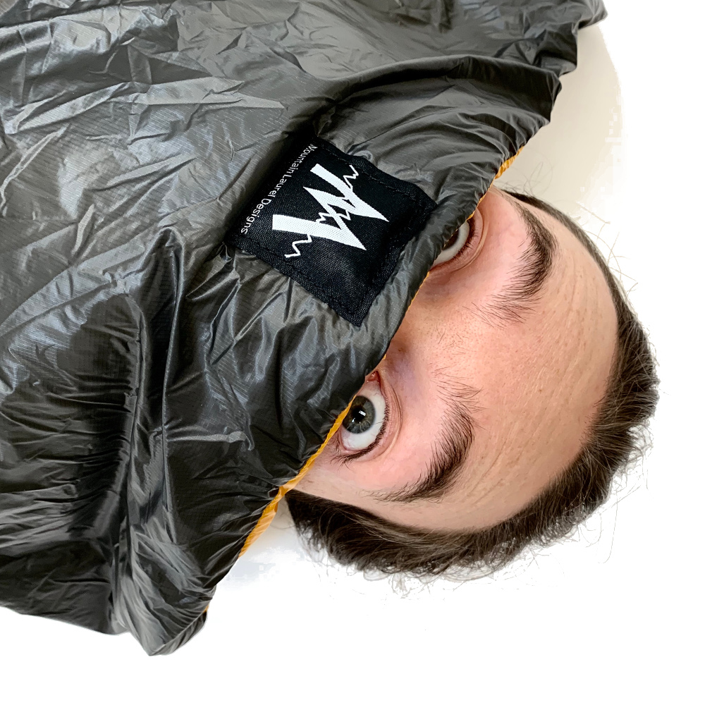 How You Look When You See a Bear in the Vision Quilt. A man's eyeballs peek out of his quilt.