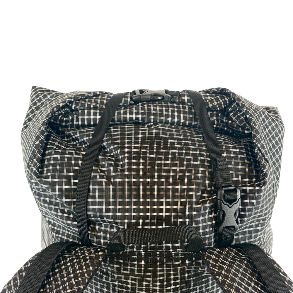 Top detail on the MLD Hell 27L pack showing the haul loop, compression strap and rolltop.