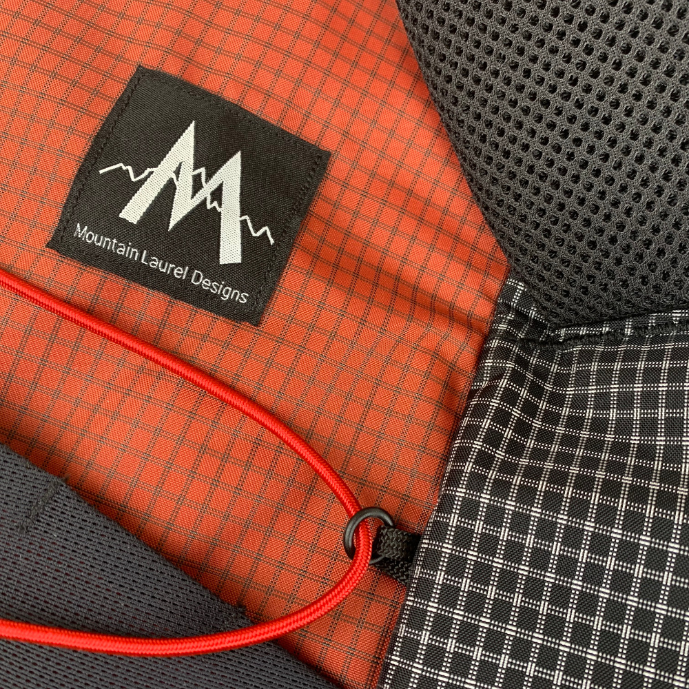 Pack details on the MLD Hell Pack showing the UltraGrid fabrics, back foam, and front bungee cord.