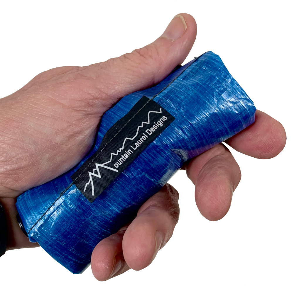 MLD Roll Top Ultralight Packing Cubes roll small and weigh only one ounce. Shown rolled-up in a hand.