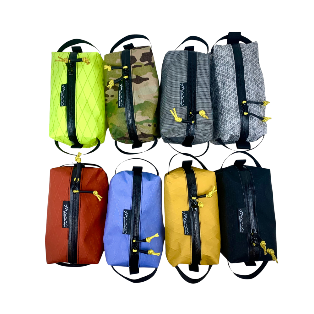 MLD Dopp Kit Bags in all 8 Available Colors (Top to Bottom, Left to Right): Hi-Viz Yellow, Camo, Medium Gray, Light Gray, Chili Red, Bluebell, Marigold, Black